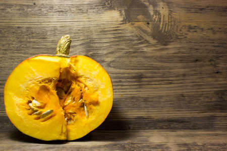 Cut slices of pumpkin seeds on wooden backgroundの写真素材
