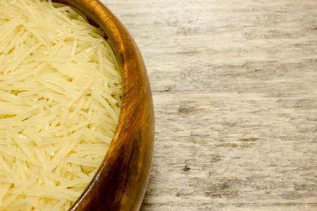 Small dry pasta noodles on wooden backgroundの写真素材