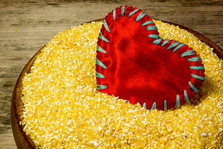 Corn grits and red heart love on wooden backgroundの写真素材