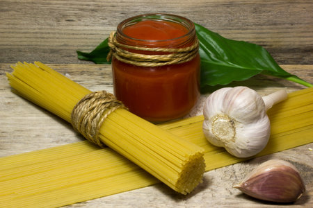 Pasta Spaghetti, garlic, tomato paste on a wooden backgroundの写真素材