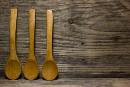 Wooden kitchen spoon on wooden background. Space for text.の写真素材