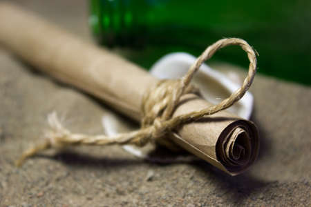 A roll of paper on the sand. Message for help.の写真素材