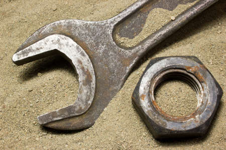 Old wrench and nuts on the sandの写真素材