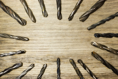 Drill bits on wooden background