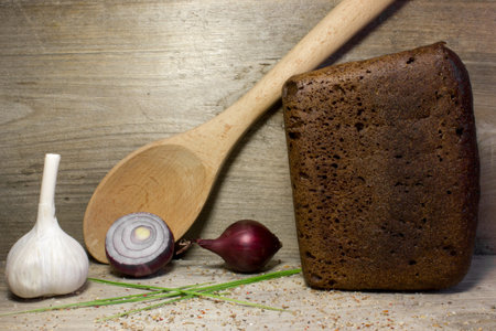 Black rye bread on wooden background.