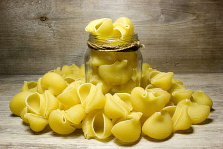 Noodles seashells on wooden backgroundの写真素材