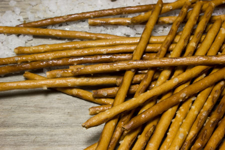 Bread sticks with salt on wooden background