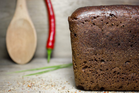 Black rye bread on wooden background.