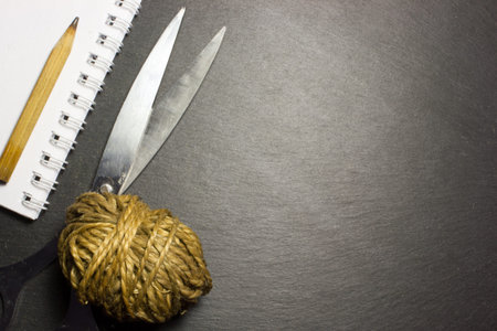 Scissors and a ball of yarn on a dark background