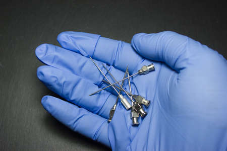 Medical iron needle from the syringe in the hands of a doctorの写真素材