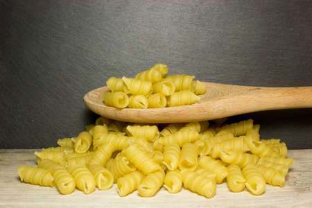 Spiral noodles and spoon on wooden backgroundの写真素材