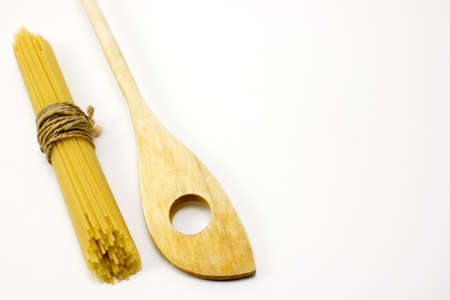 Wooden spoon and pasta on a white backgroundの写真素材