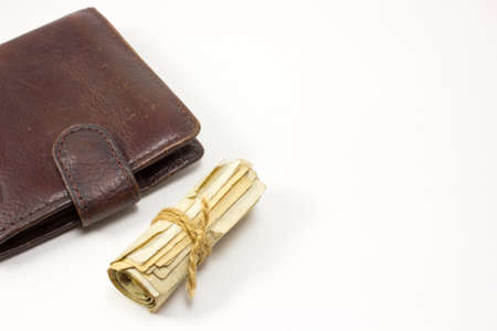 Wallet and a Roll of money tied with a rope on white backgroundの写真素材