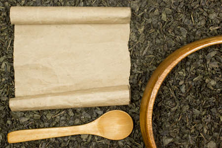 Dry green tea, a blank sheet of paper and a wooden spoon. Place for textの写真素材