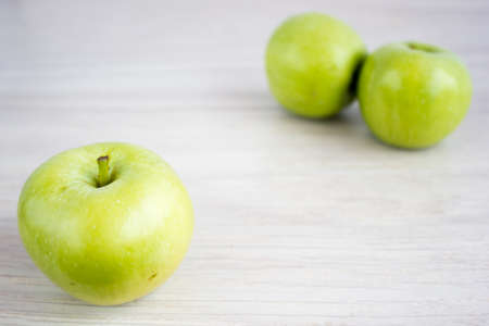 Three green apples on the tableの写真素材