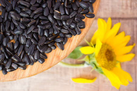 Seeds and flowers of sunflower on woodenの写真素材