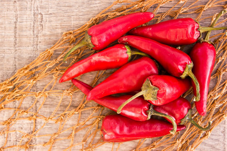 Some red spicy chili peppers on wooden table