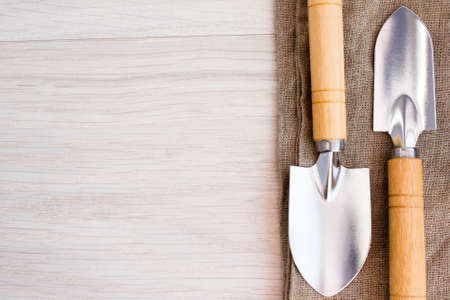 Trowel and tools on sackcloth on wooden tableの写真素材