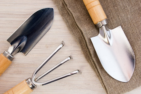 Trowel and tools on sackcloth on wooden table