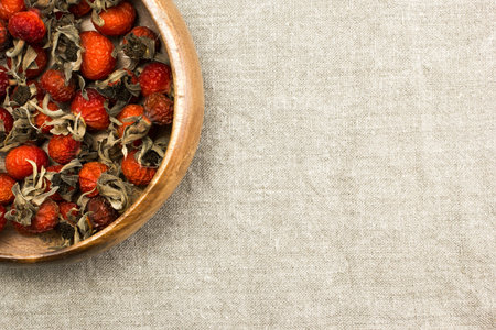 Dried berries rose hips in a bowl on burlap on the table