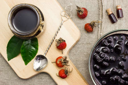 Jam from currants in a bowl with vintage spoon on the table, dogrose berriesの写真素材