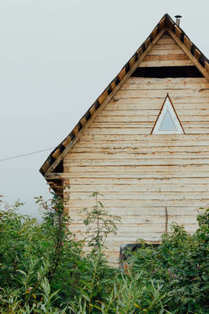 Wooden travel house with a triangular window in the taiga grass.の写真素材