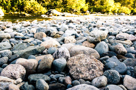 Stones, pebbles and sand on the shore of a mountain riverの写真素材