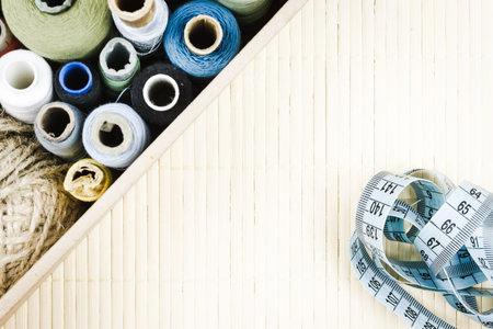 Skeins of thread and inch for sewing as a backdrop. Needlework, tailor hobby.