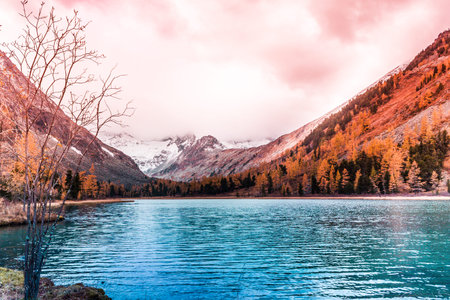 Mountain lake with reflection in the mirrored surface of the rocks in cloudy rainy weather in the...