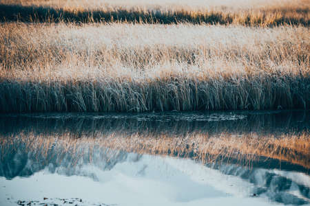 Reflection of peaks of rocks in the mirror of a mountain lakeの写真素材