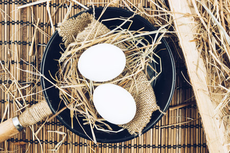 Two whole eggs in a cast iron frying pan on a wooden table. Cooking eggs.