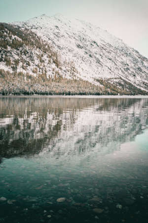 Mirror surface of the lake with a mountain range on the horizon. Travel to the national Park in the Altai mountains.の写真素材