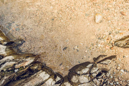 Stones, pebbles and sand on the shore of a mountain riverの写真素材
