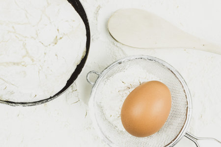 The ingredients for baking. The egg and the dough in the plate. Preparation of homemade bread.