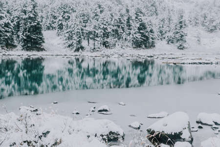 Mirror surface of the winter lake with a mountain range. First snow in the mountains. Travel to the national Park in the Altai mountains.の写真素材