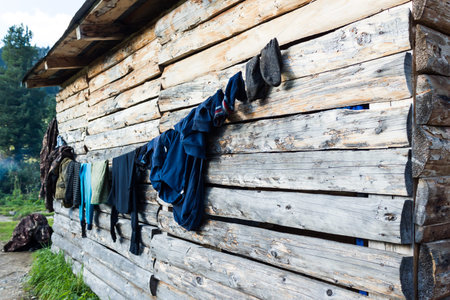 Clothes are dried on the wall of a wooden houseの写真素材