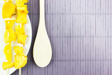 Pieces of pumpkin on wooden sticks on a white plate. The skewers of pumpkin. Copy space for textの写真素材