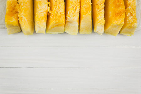 Pieces of fresh pumpkin on a white wooden table.  Copy space for text