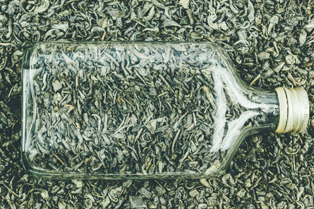Dry green tea and glass bottle