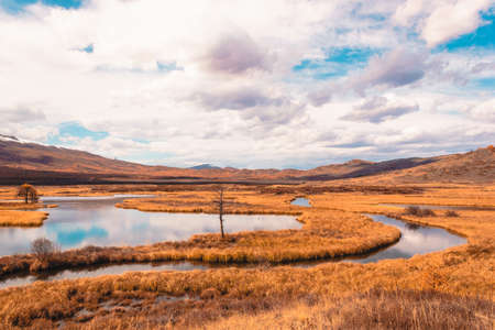Autumn panorama. View of mountains and lake. Mountain range on horizon. Travel to mountain valley with rivers.の写真素材