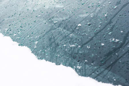 Snow and raindrops on glass as background.の写真素材