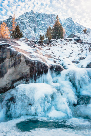 Winter mountain river under ice. Water froze and turned into icicles.
