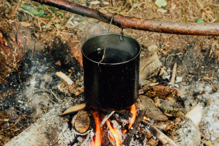 Tourist bowler on fire. Tourism, cooking in field conditions. Wild forest conditions for survival.