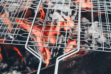 Metal grill on open fire. Cooking barbecue at picnic.の写真素材