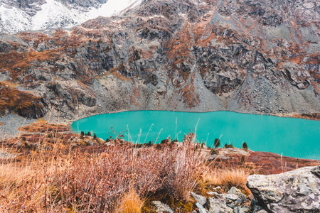 Turquoise lake in mountains. River in rocks in fall. Travel in mountain valley