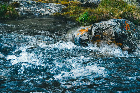 Strong mountain river. Rapid flow of stream among rocks. Blue stream of water seethes in rocksの写真素材