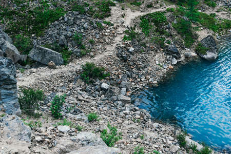 Rocky shore of blue lake. The surf of turquoise sea, waves come to shoreの写真素材