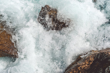 Turquoise water in river with stone shore. Sea tide, seething blue water in mountain stream
