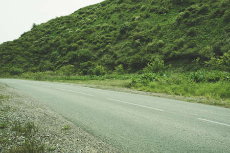 Asphalt road in green hills. Mountain road in forestの写真素材