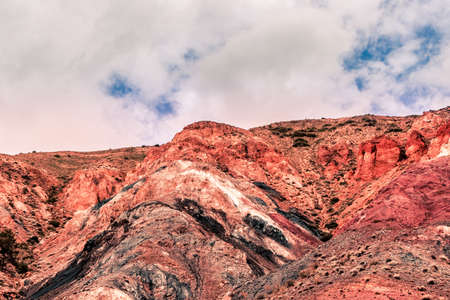 Colored hills in mountain valley. Dry sandy red hills on hot summer day. Drought, climate change. Soil erosion in ravinesの写真素材